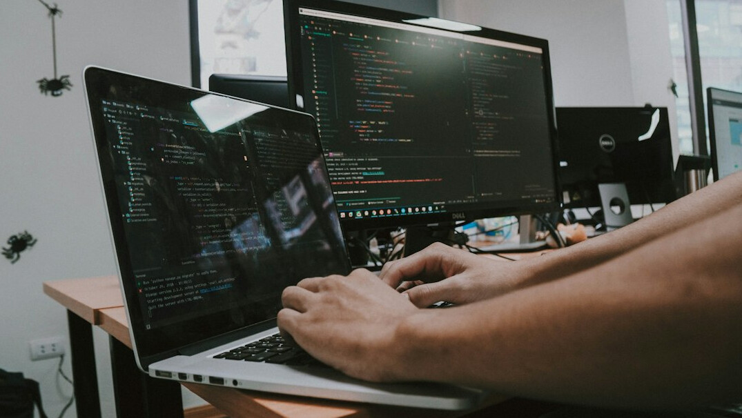 programmer coding on laptop